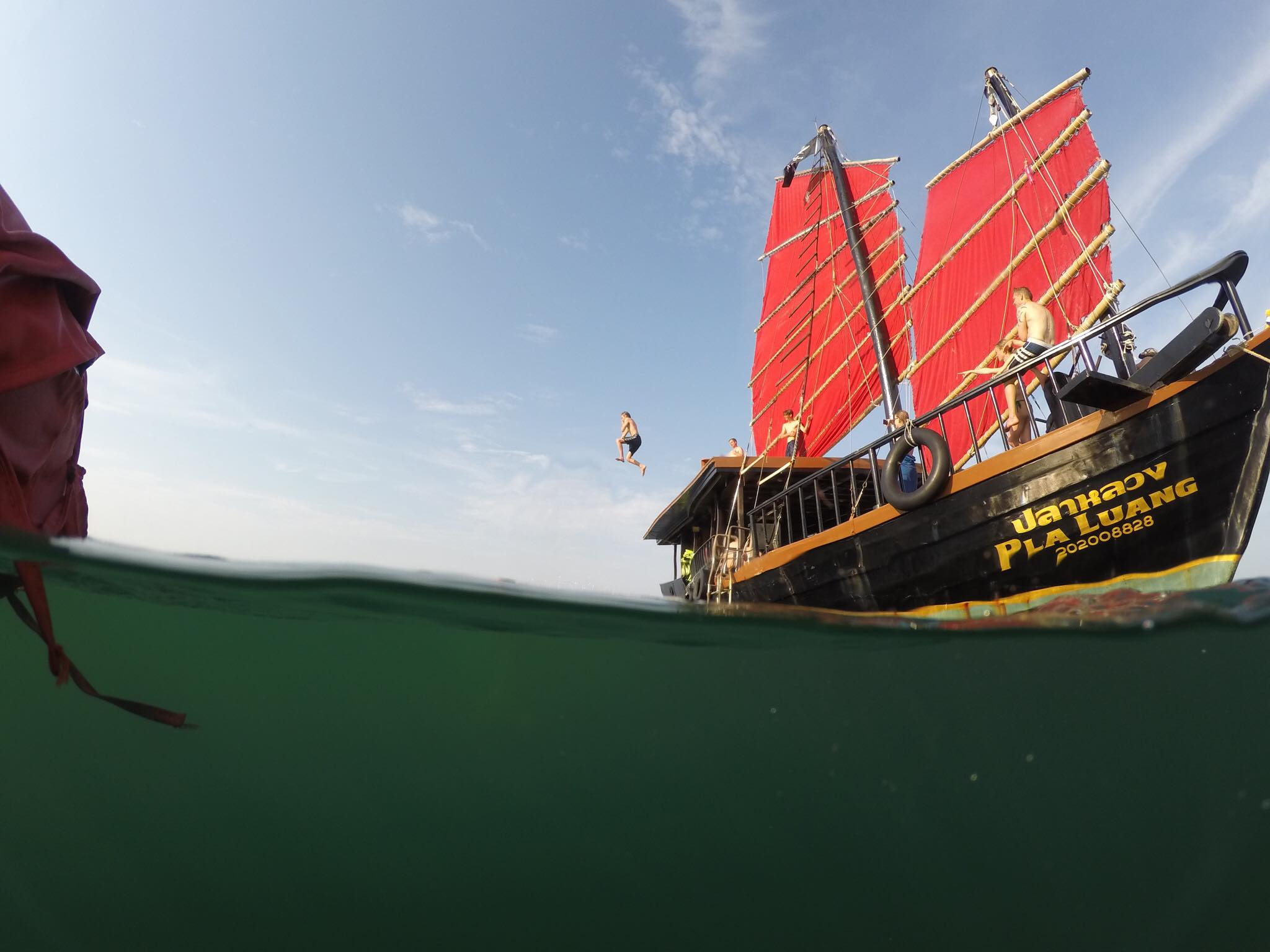 krabi boat photo prise depuis le niveau de la mer montrant un homme sautant d'un bateau à deux étages