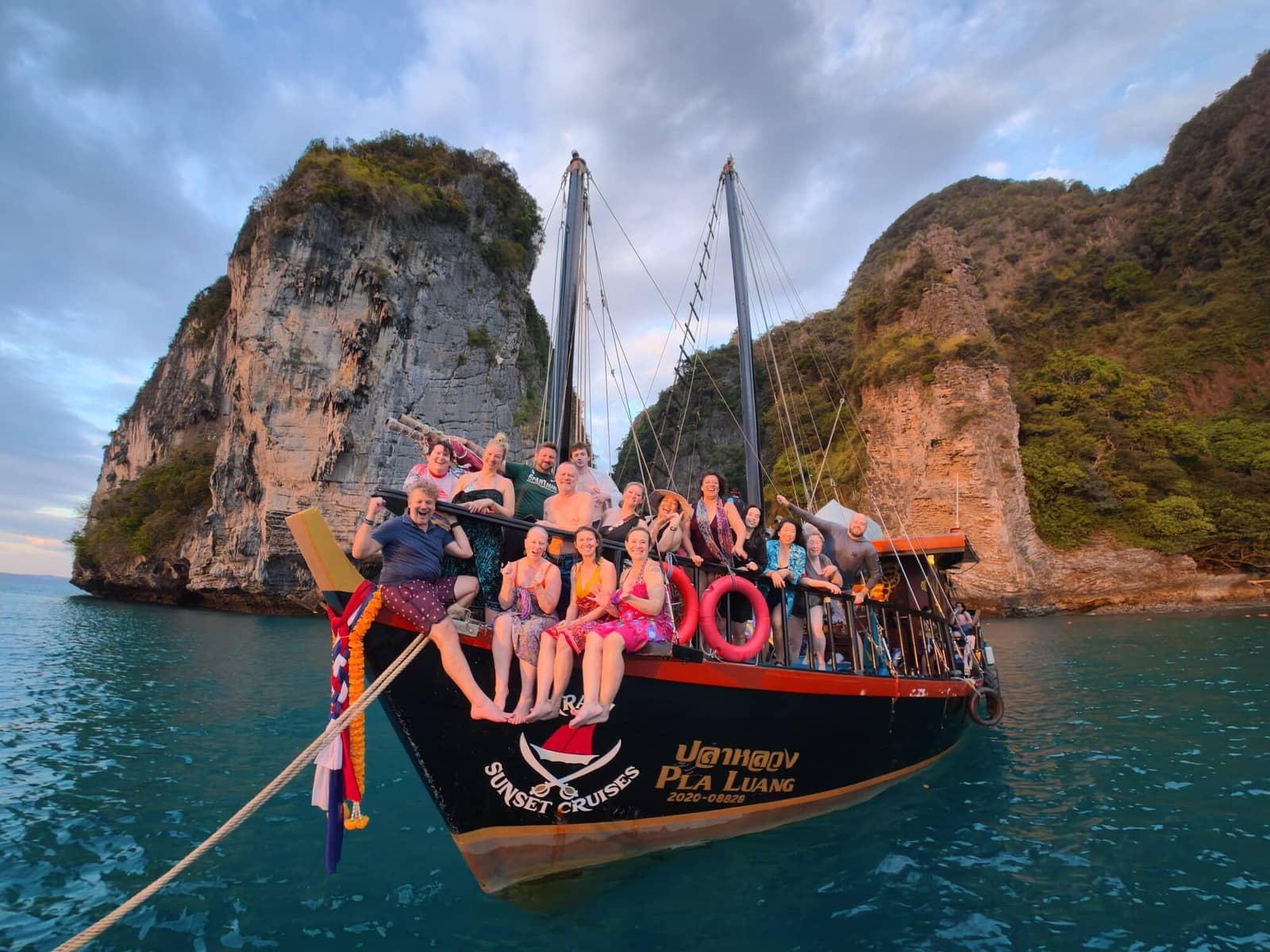 Private group posing on the front of Krabi Sunset Cruises boat on a 4 island tour.