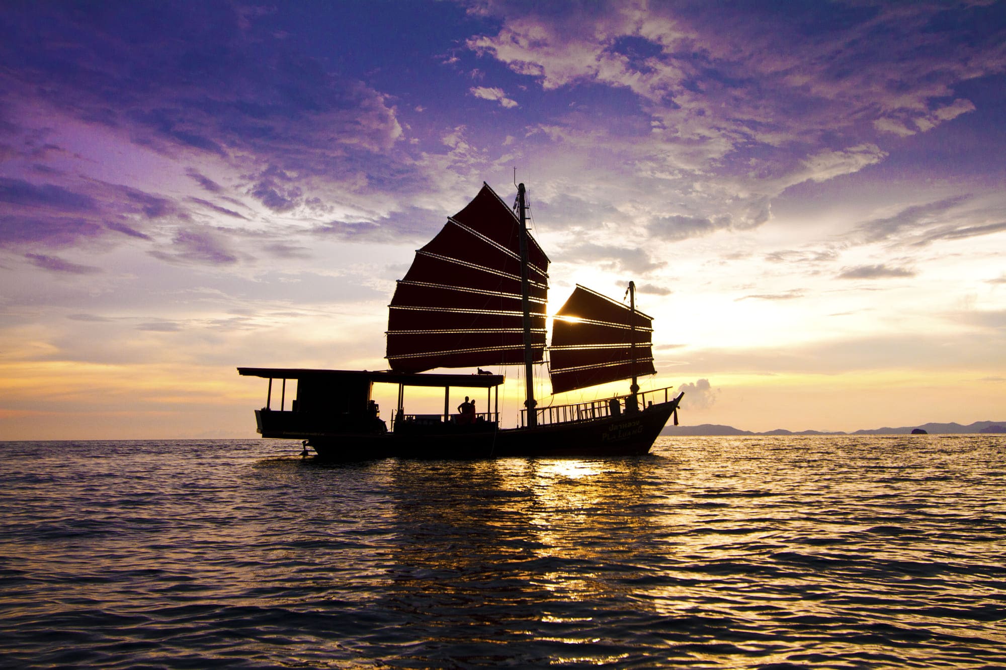 Silhoutte of guests on a Krabi Sailing Tour boat on a Krabi Sunset Cruise with sunset in the background