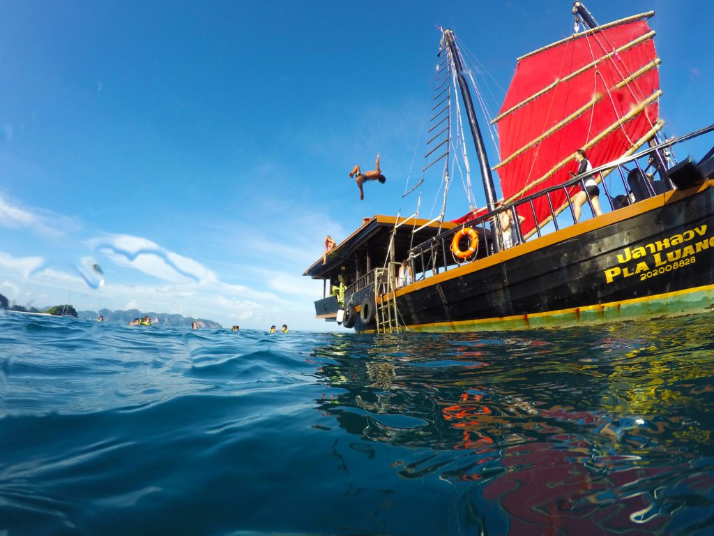 Gente saltando del barco Krabi Sunset Cruise al mar