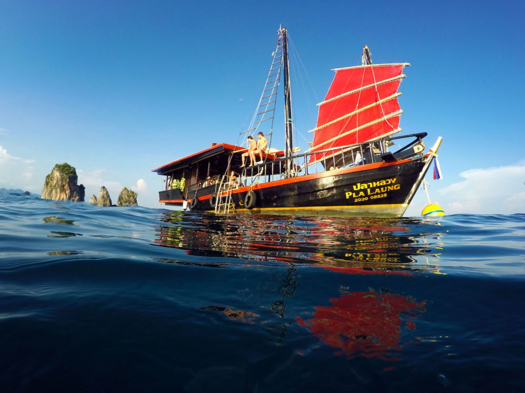 Invitados a bordo del crucero Krabi Sunset Cruise con el cielo azul y las islas de fondo