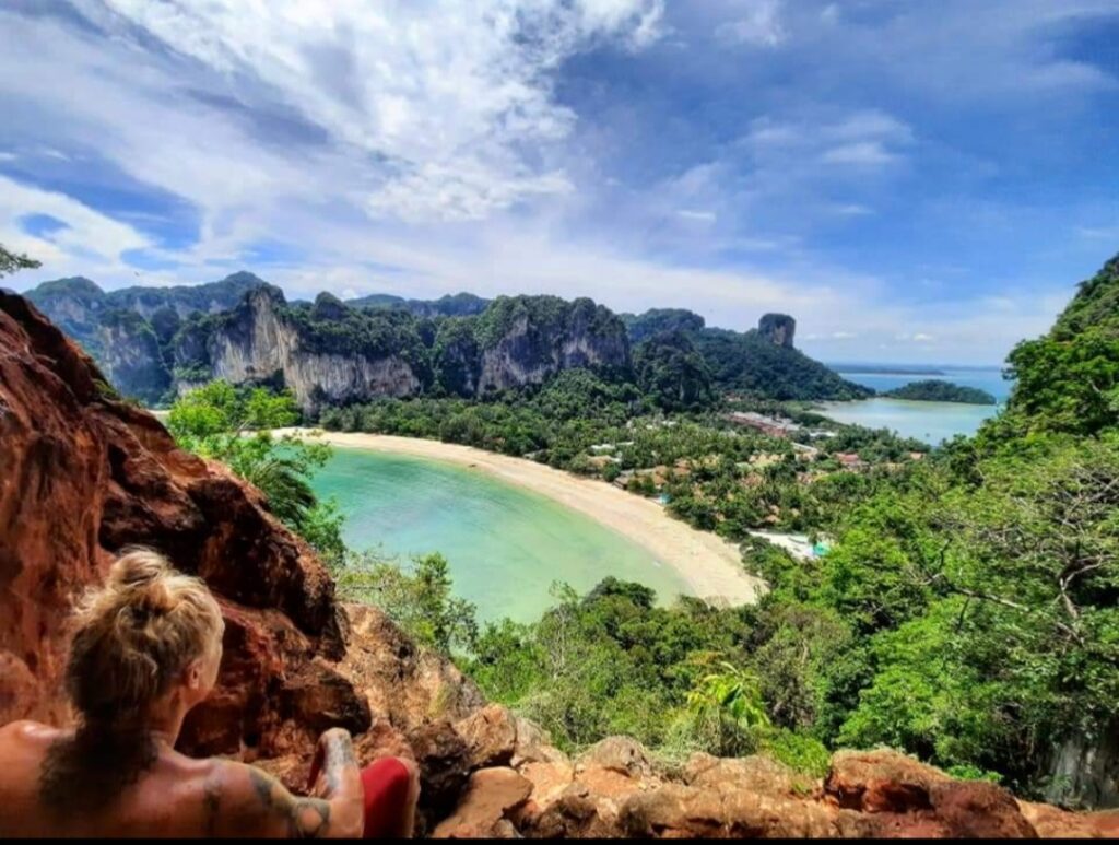 a climber looking over railay west beach from high up in the limestone cliffs