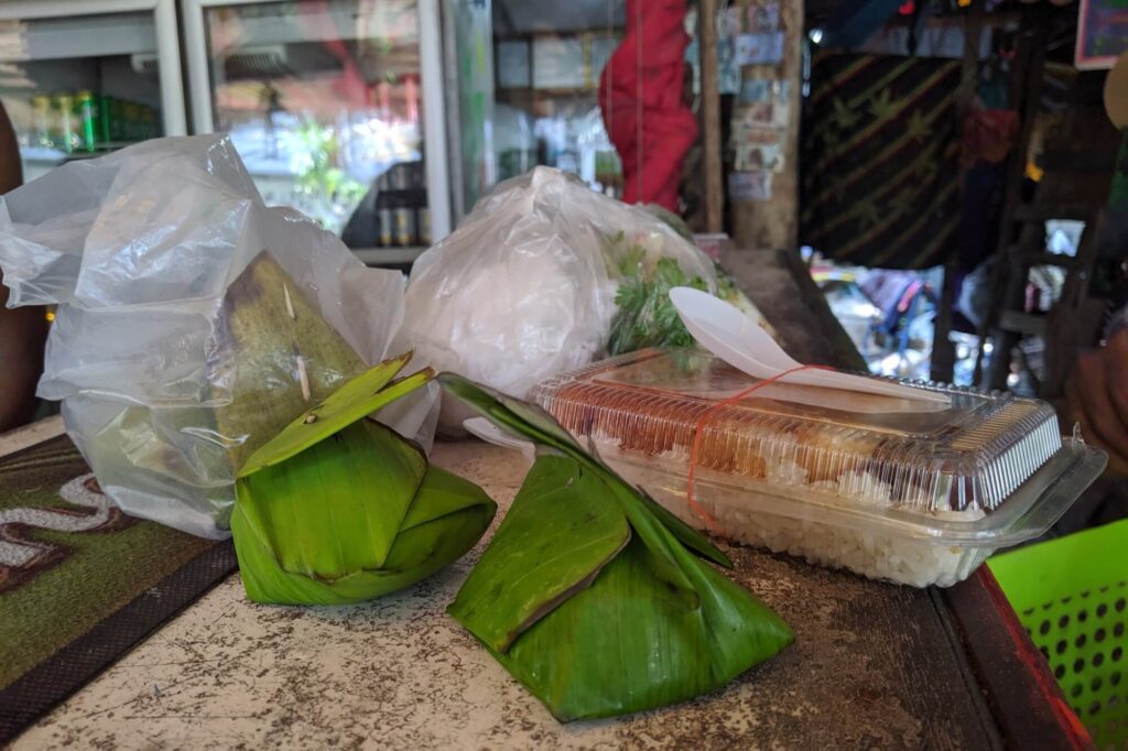 una selección de comida tailandesa de picnic en krabi, incluidos dulces envueltos en hojas de plátano y cajas de arroz
