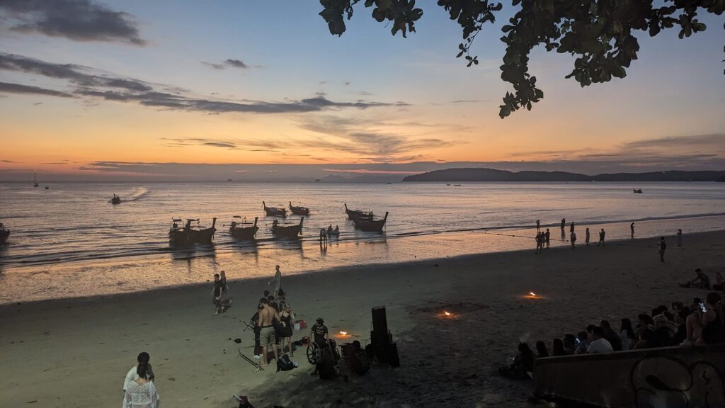 la playa de aonang al atardecer con barcas de cola larga en la orilla