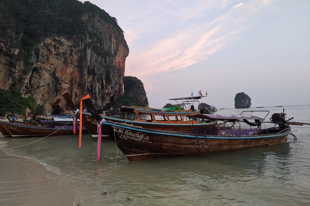 lanchas esperando en la orilla de railay al atardecer