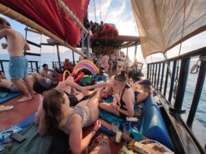 membres du groupe contiki allongés sur le pont d'un bateau pirate en thailande