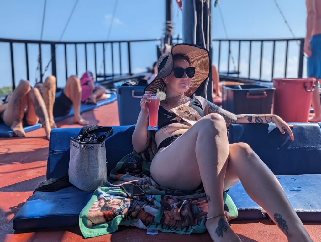 a boat guest in krabi drinking a cocktail in the shade of the deck