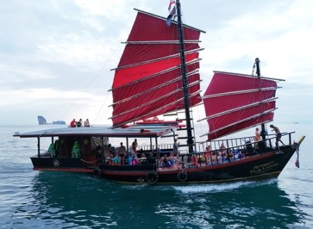 Traditional Thai junk boat with red sails cruising in the Andaman Sea with guests onboard
